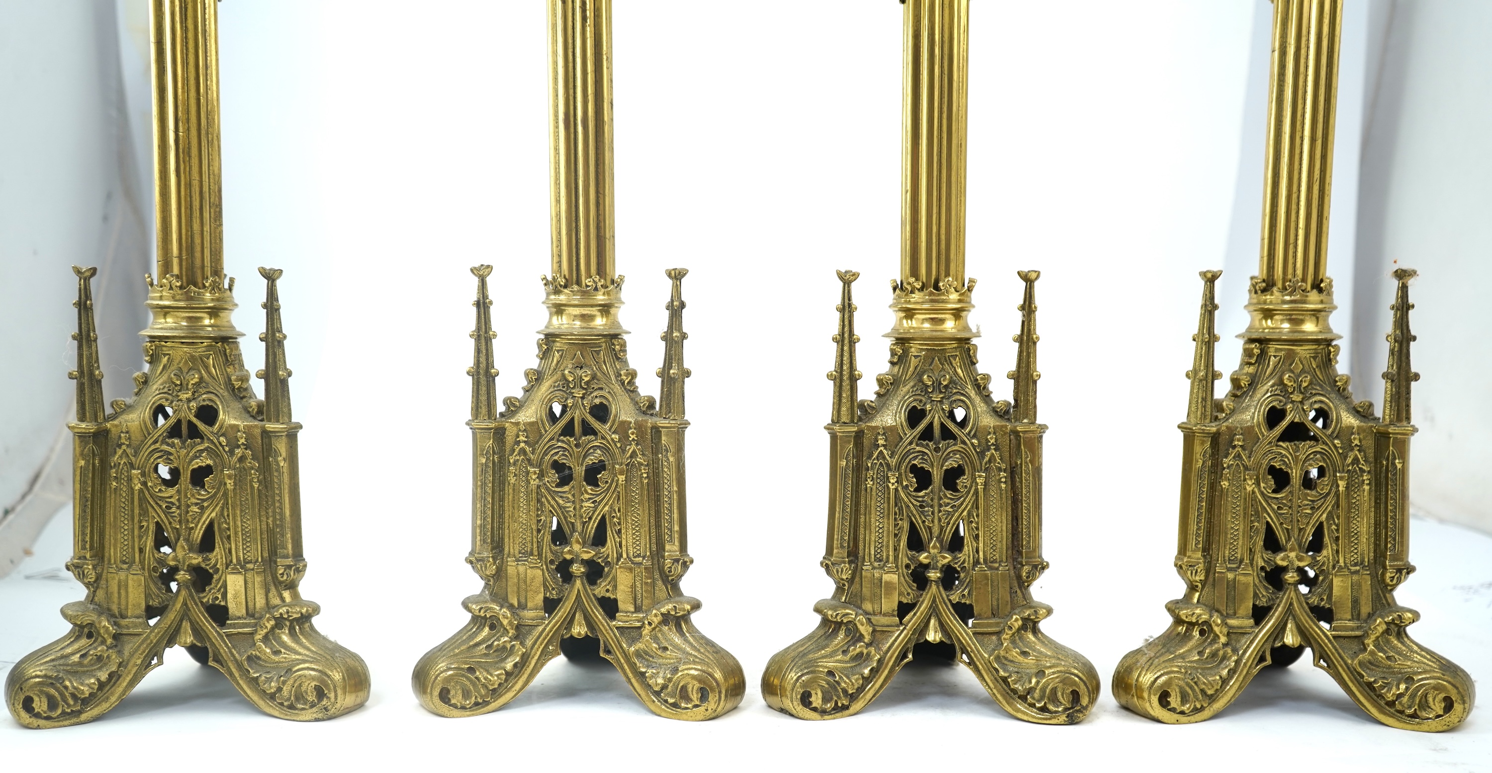 A set of four Gothic revival brass altar candlesticks